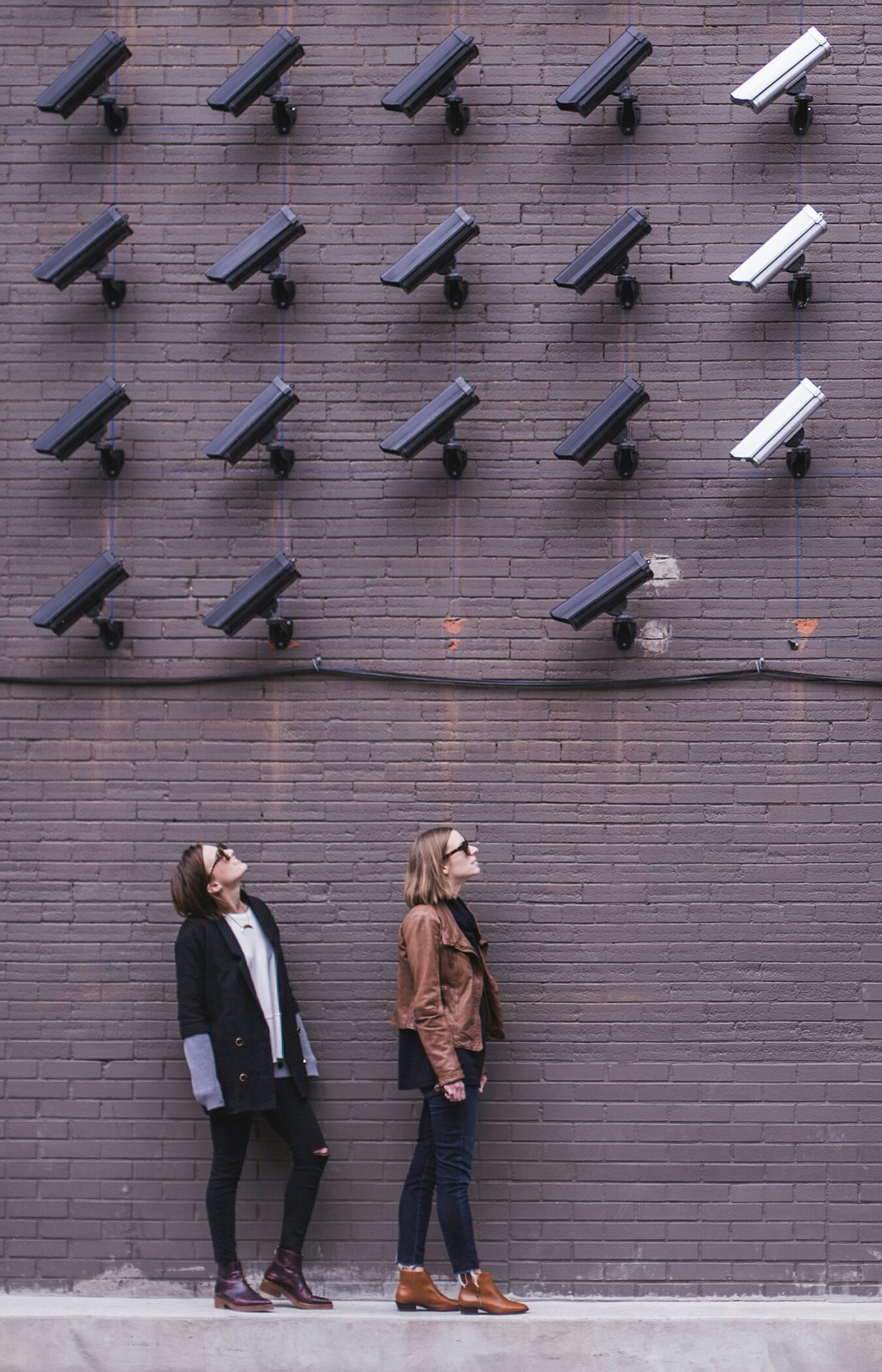 Frauen vor einer Wand voller Überwachungskameras